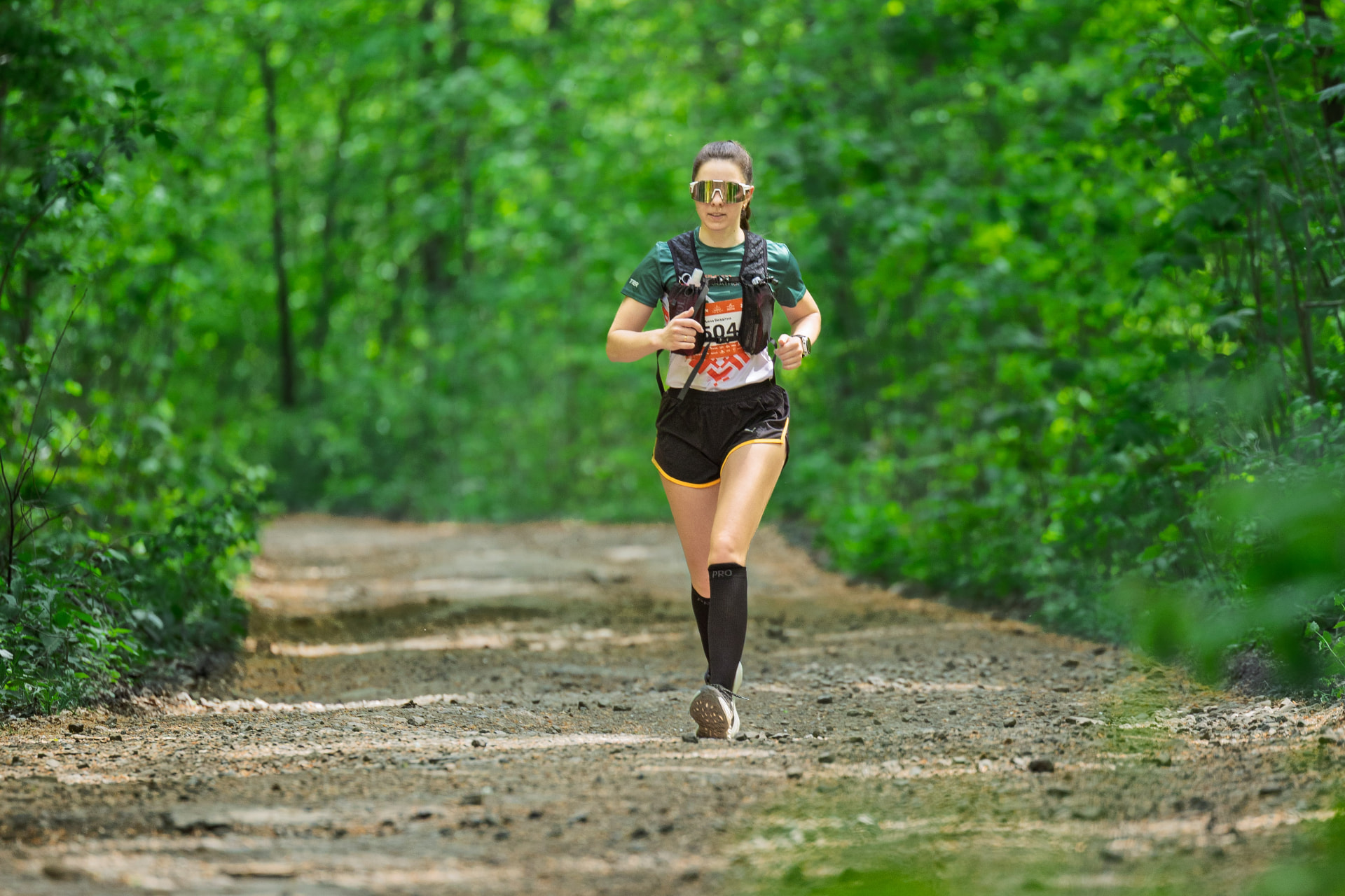 Бігунка на лісовій стежці трейлу UZHTRAIL